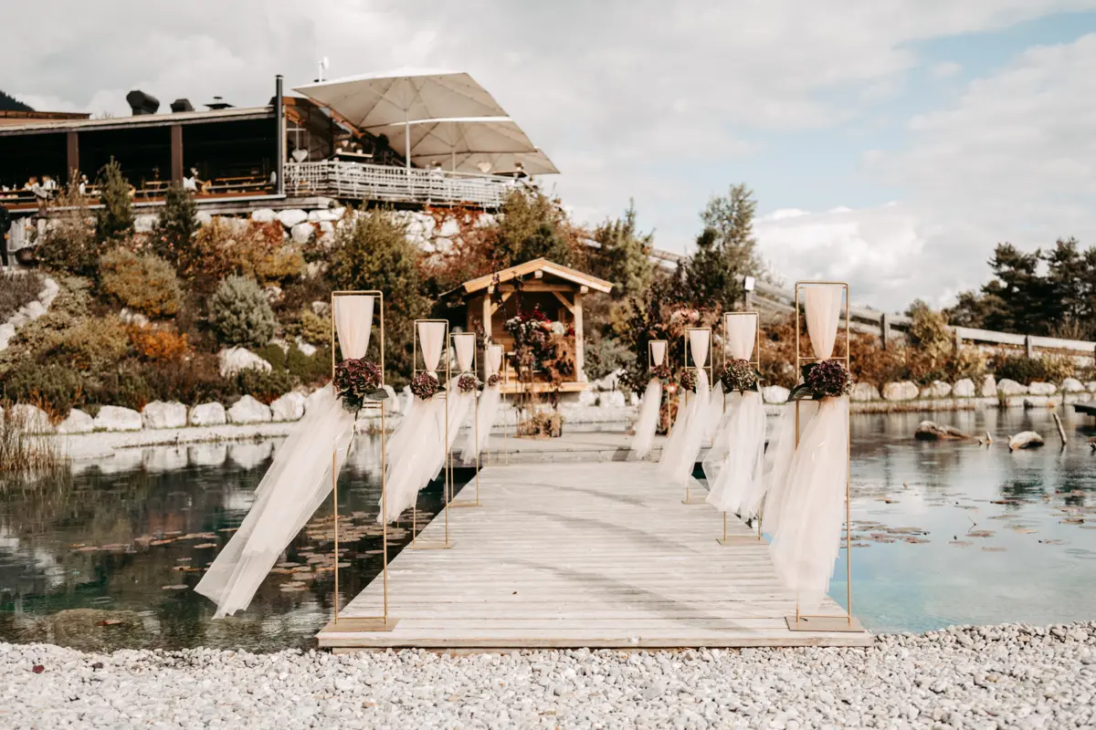 Geschmückter Hochzeitssteg am Naturteich der Stöttlalm führt zum Zeremonien-Pavillon