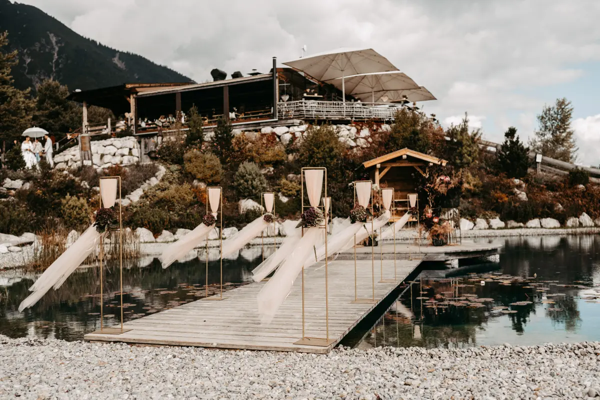 Hochzeitlich dekorierter Steg über den Bergsee der Stöttlalm mit Trau-Pavillon – Kulisse für Trauungen in Tirol