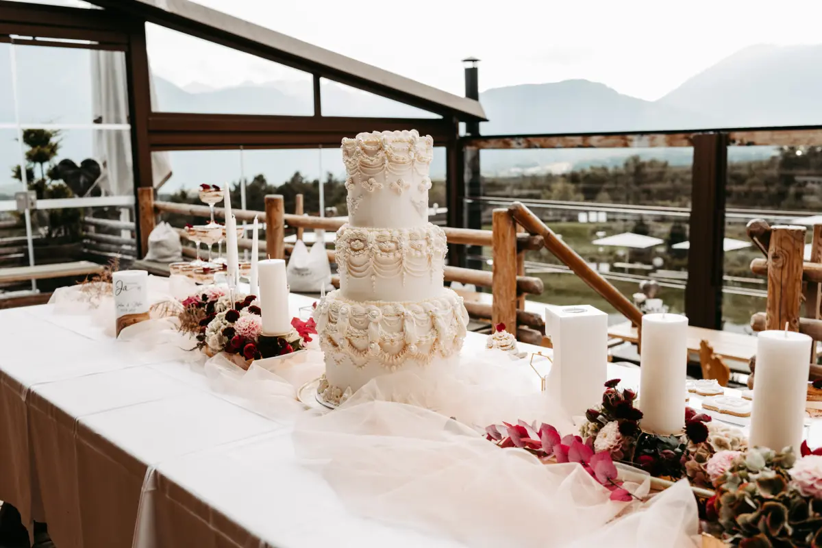 Hochzeitstorte auf dem dekorierten Sweet Table der Stöttlalm mit Bergblick in Tirol